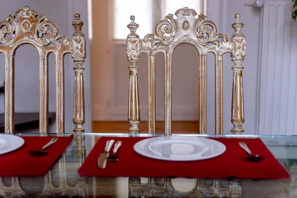 La cuisine sur la table assiettes en porcelaine fourchette, couteau, et deux chaises vintage contre la fenêtre — Photo