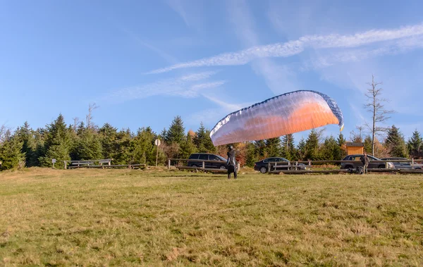 Paraglider is ready to take off over a green hill — Stock Photo, Image