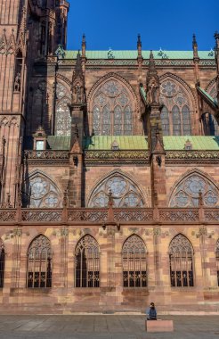 Büyük kilise yanında oturan küçük kişi