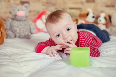 Portre portre görüntülemek bir komik dört gözle yumuşak battaniye ile yatakta yatarken sarı saçlı sevimli küçük oğlu gülümseyen