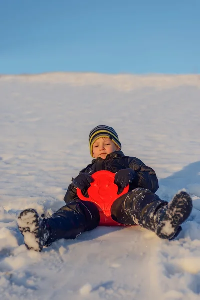 Menino feliz se divertindo na neve de inverno — Fotografia de Stock