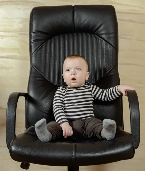 Retrato divertido de un chico lindo en una silla de oficina —  Fotos de Stock