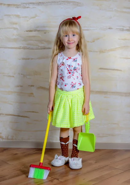 Adorable niña con una escoba de juguete y una sartén —  Fotos de Stock
