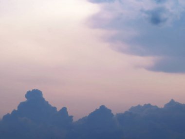 Fırtınalı bulutlar gün batımında hareket ediyor Mor bulutları ve pembe gökyüzünü ortaya çıkarıyor