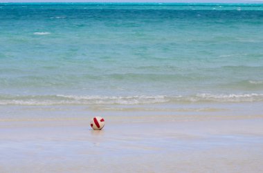 Karayipler 'deki turkuaz okyanusun önündeki kumlu sahilde tek başına bir futbol topu.