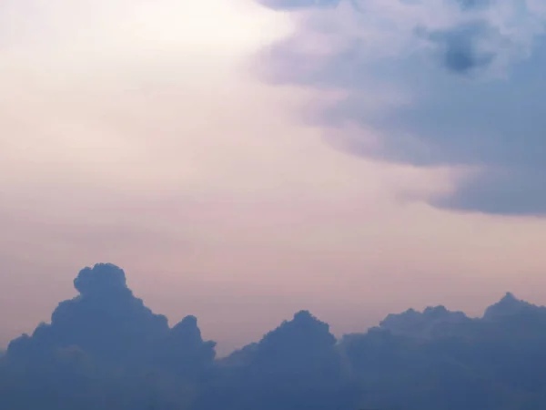 Fırtınalı bulutlar gün batımında hareket ediyor Mor bulutları ve pembe gökyüzünü ortaya çıkarıyor