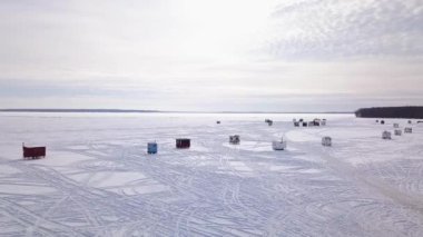 Donmuş gölün üzerinden uçarak güzel bir günbatımı ve buzun üzerinden geçen bir kar aracını gösteriyor.