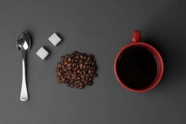 Kahve fincanı kahve çekirdekleri ve çay kaşığı beyaz şeker küpleriyle