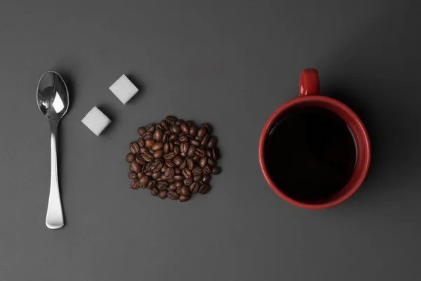 Кавова чашка з кавовими зернами та чайною ложкою з кубиками білого цукру — стокове фото