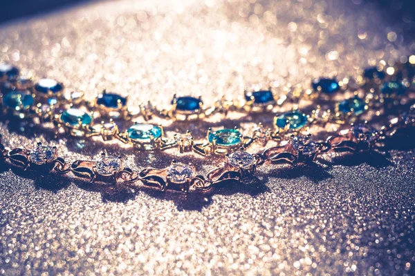 Золотые браслеты с голубыми и белыми камнями — стоковое фото