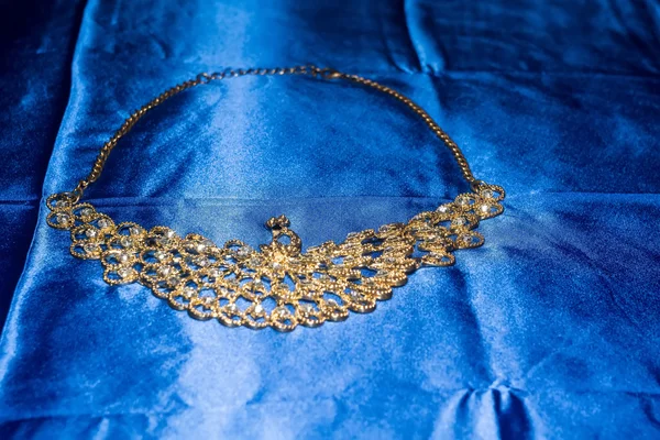 Золотое ожерелье на голубом фоне — стоковое фото