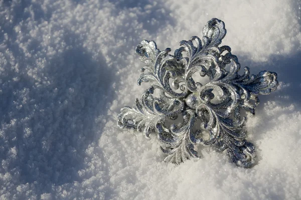 Copo de nieve de plata en la nieve — Foto de Stock
