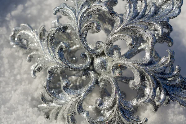 Silberne Schneeflocke auf Schnee — Stockfoto