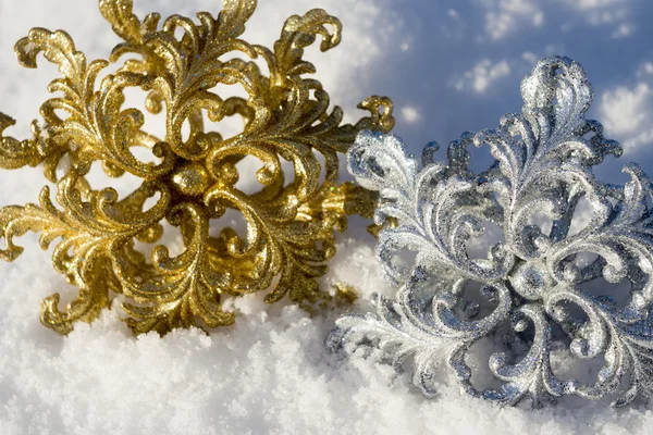 Gold und Silber Schneeflocke auf Schnee — Stockfoto