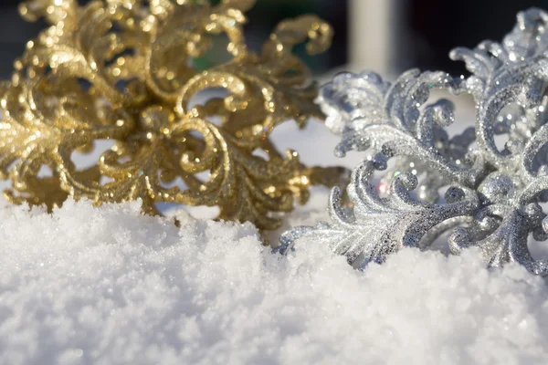 Copo de nieve de oro y plata sobre nieve — Foto de Stock