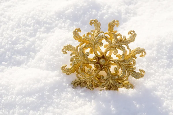 Floco de neve dourado na neve — Fotografia de Stock