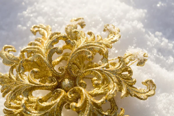 Goldene Schneeflocke auf Schnee — Stockfoto