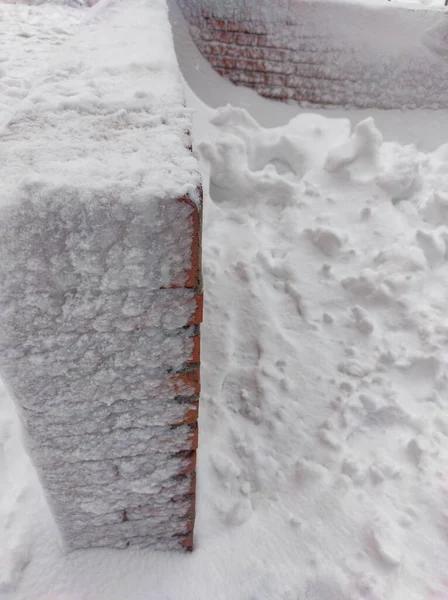 街道上的小砖墙完全被雪覆盖了 — 图库照片