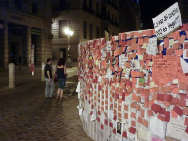 Madrid, İspanya; 23 Mayıs 2011. Puerta del Sol.Fotoğraf: 23 Mayıs 2011 'de Madrid, İspanya' da çekilen bir inşaat sahasının çitlerine bir sürü not kağıdı ve protesto afişleri asıldı.