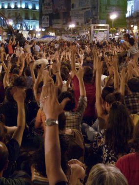 Madrid, İspanya; 29 Mayıs 2011. Madrid 'deki Puerta del Sol' daki 15-M hareket kampında düzenlenen mitingde insanlar alkış tutuyordu. Fotoğraf: 29 Mayıs 2011, Madrid, İspanya