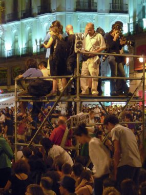 Madrid, İspanya; 29 Mayıs 2011. 15-M hareketi sırasında Madrid 'deki Puerta del Sol' da bir mitingde iskele başında duran insanlar. Fotoğraf: 29 Mayıs 2011, Madrid, İspanya