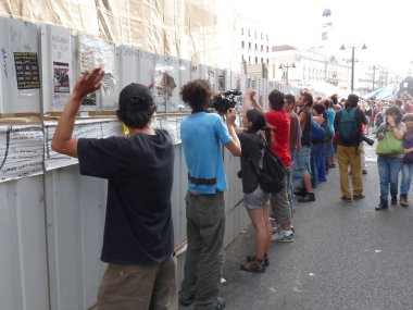 Madrid, İspanya; 11 Haziran 2011. Protestocular protesto için inşaat alanındaki bir bariyere çarptılar. Madrid 'deki Puerta del Sol' da 15-M Indignados protestosu. Fotoğraf 11 Haziran 2011 'de Madrid, İspanya' da çekildi.