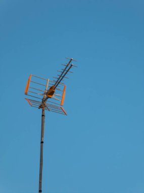 Güneşli bir günde açık mavi gökyüzünün altında telekomünikasyon anteni