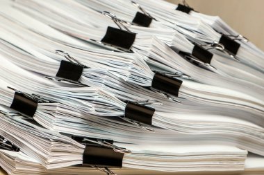 Bir tomar kağıt doküman. Paketler ofisteki masanın üzerine yığılır.