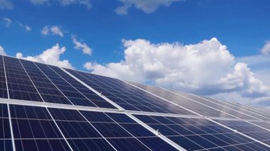 Bulutlu mavi gökyüzünün arka planındaki güneş panelleri. Temiz enerji kavramı, yeşil enerji, yenilenebilir enerji..