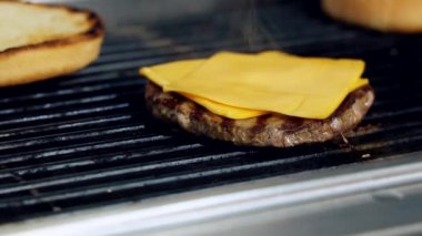 Peynirli et, ızgarada kızarıyor. Kızartma ızgarasında çizburger malzemesi hazırlıyorum. Lezzetli fast food yapıyorum. Yakın plan..