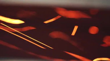 Kavisli yansımaları olan soyut turuncu ve kırmızı ışık desenleri. Alev hareketini ve kırılan enerjiyi gösterir.