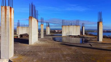 Düz çatı, çelik takviye kuvvetleri ve su birikintileri, su birikintisinin yanında. Beton levha ve dikey demir kolonlar. Hava görünümü.
