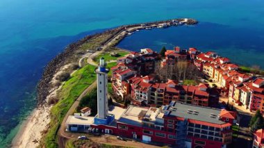 Renkli binalar, dolambaçlı yollar ve kıyı şeridindeki deniz fenerinin yanında tekneleri olan limanlar. Bulgaristan 'daki Karadeniz' in havadan görünüşü.