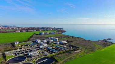 Sahil şeridi, kasaba ve iskele yakınlarındaki su arıtma tesisi. Çevresel ve kentsel planlama dengeli. Hava görünümü.