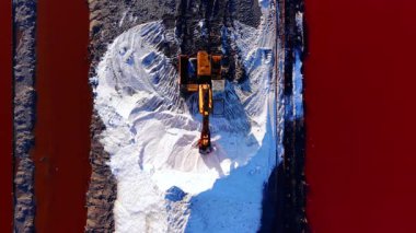 Beyaz bir tuz sırtı üzerindeki kazıcının yukarıdan aşağıya görüntüsü. Su, değişik pembe ve mavi tonlarda buharlaşmanın farklı aşamalarıdır..
