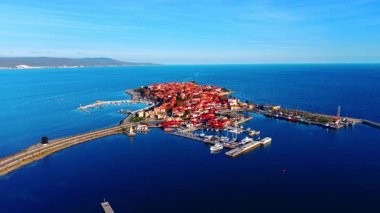 Anakaraya giden bir yola bağlı dar bir yarımadada küçük tarihi bir kasaba. Mavi su ada benzeri karayı çevrelemektedir. Gökyüzü açık. Hava görünümü.