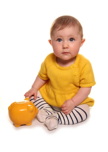 Menina bebê com um banco piggy amarelo — Fotografia de Stock