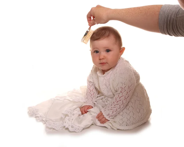 Madre pettinando babys ragazze capelli prima del battesimo — Foto Stock