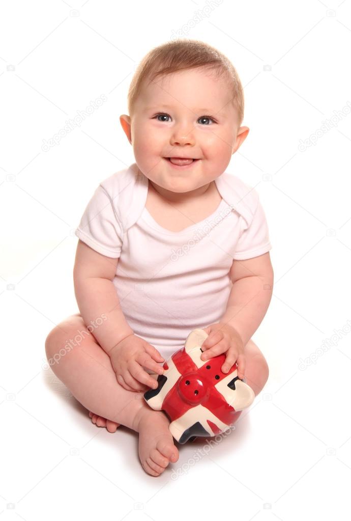 Baby girl looking happy with british piggybank