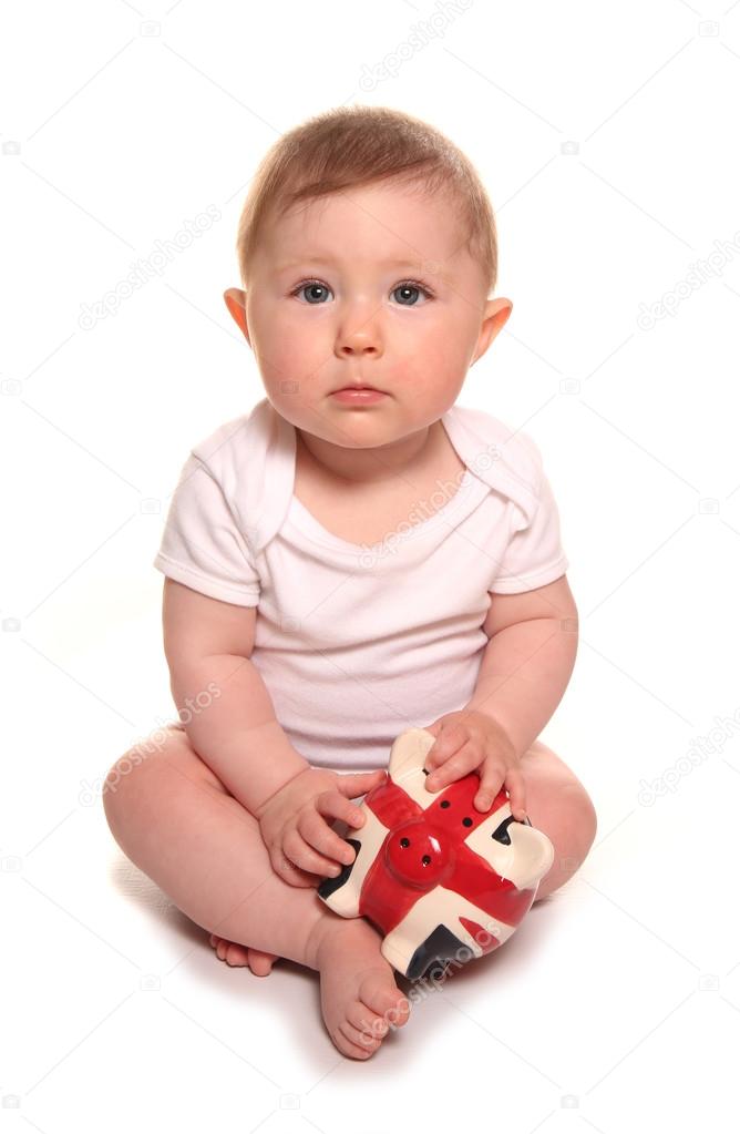 Baby girl looking sad with british piggybank