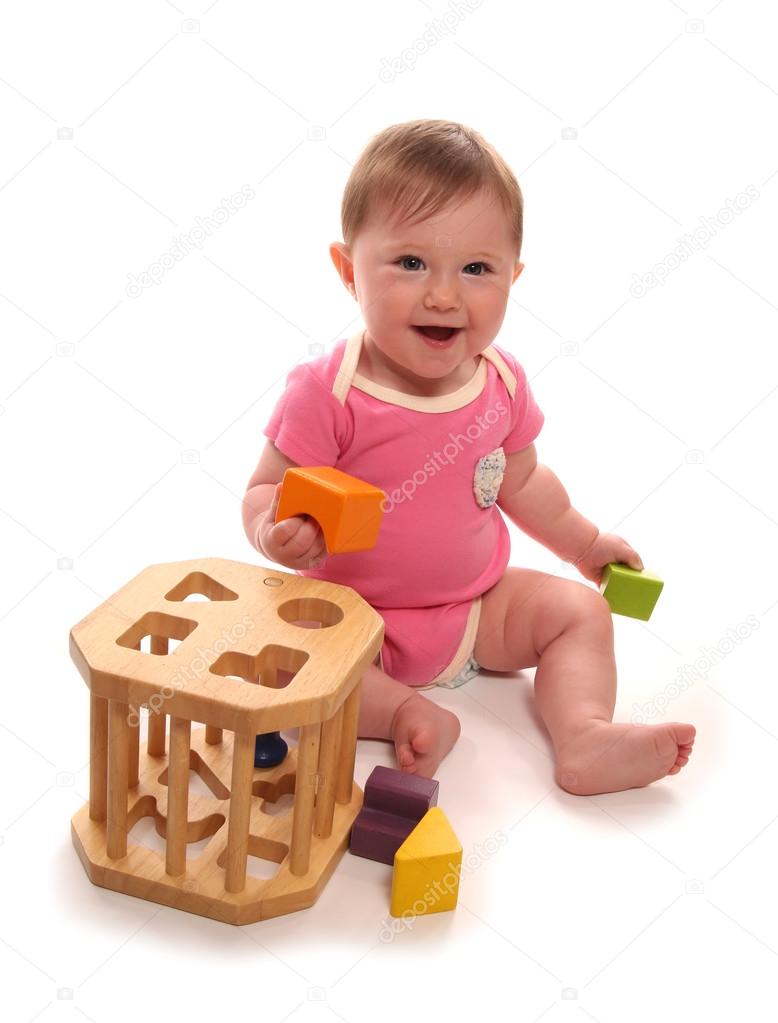 Baby girl playing with wooden shape sorter