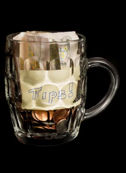 Bar staff tips in a pint glass — Stock Photo, Image