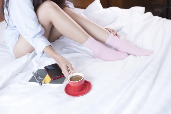 Молодая азиатка сидит на кровати в носках — стоковое фото