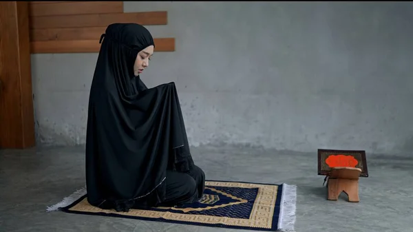 Fiatal Gyönyörű Muszlim Fekete Hidzsábot Visel Szőnyegen Imádkozik Olvassa Szentírásokat — Stock Fotó
