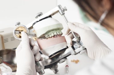 Dental technician working with articulator clipart