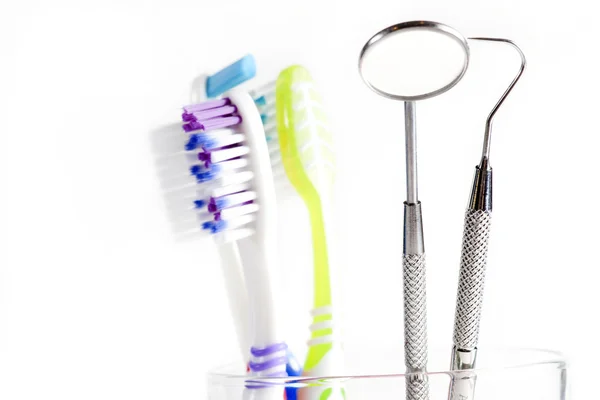 Tandenborstel en tandheelkundige spiegel - explorer in glas — Stockfoto