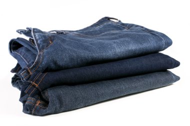 Beyaz arka planda katlanmış mavi kot pantolon yığını