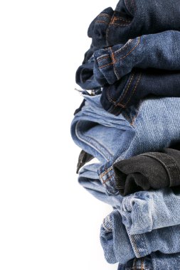 Beyaz arka planda katlanmış mavi kot pantolon yığını