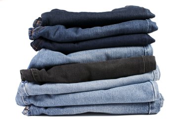 Beyaz arka planda katlanmış mavi kot pantolon yığını