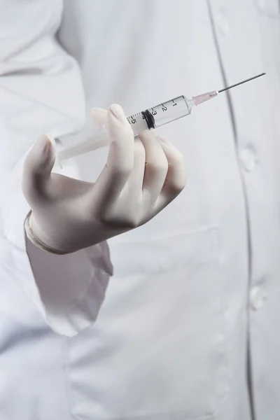 Läkare eller sjuksköterska hålla en spruta redo en injektion — Stockfoto